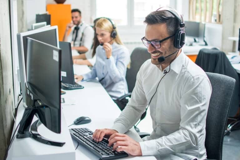 Young male technical support dispatcher with headset smiling