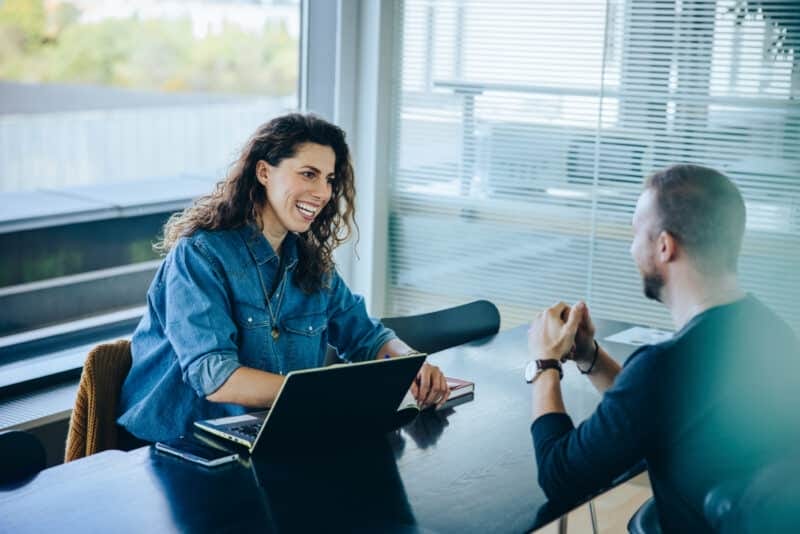 Two people in a meeting smiling